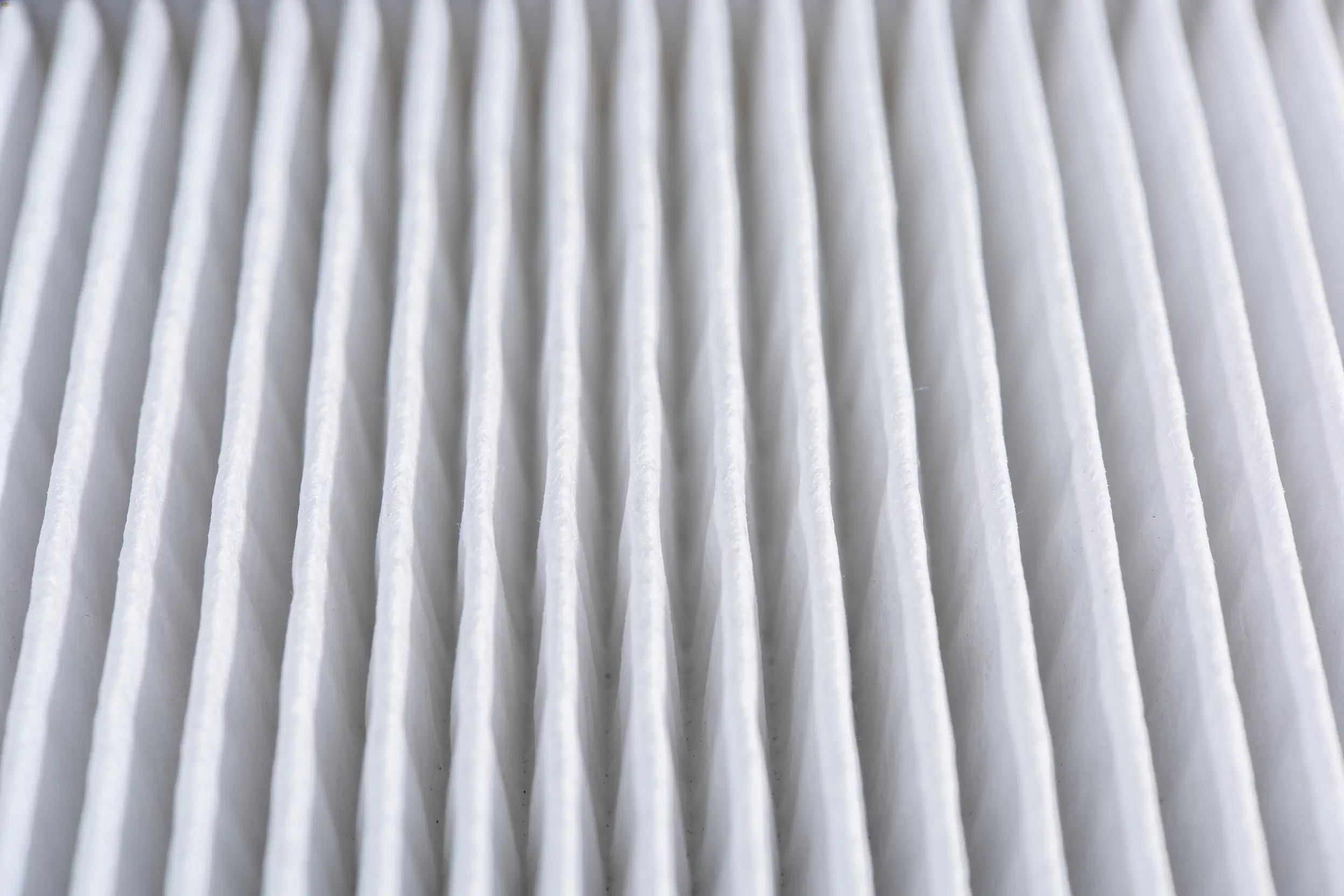 Macro view of the accordion pleats of a clean white air filter